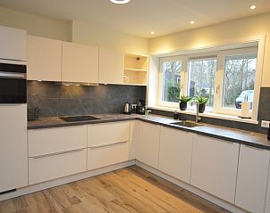 Moderne Kche im Ferienhaus De Nagtegaal 23, De Dennen, Texel, mit Blick in die Umgebung.