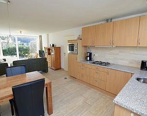 Open kitchen and dining area in Holiday home the Pearl 198, De Dennen, Texel with wooden furniture.