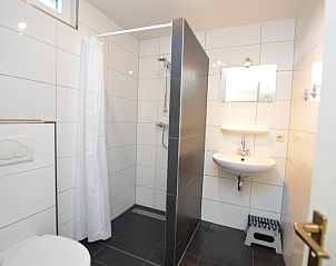 Modern bathroom in Holiday home de Parel 198, De Dennen, Texel with shower and sink.
