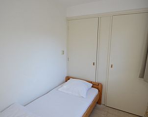 Simple single room in Holiday Home de Parel 198, De Dennen, Texel with wooden bed.