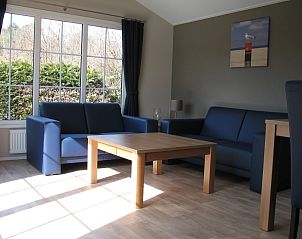 Helles Wohnzimmer von Villetta Sauna, Texel, mit bequemen Sofas und Blick auf die Natur.