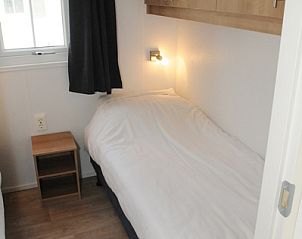 Gemtliches Einzelzimmer in Villetta Sauna, De Dennen, Texel mit Holzschrank und Fenster.