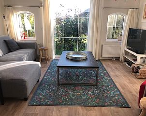 Stylish living room in Holiday Park de Bremakker, Akkerveld 15, De Dennen Texel, with large windows and comfortable sofa.