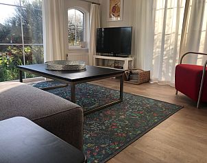 Light seating area in Holiday Park de Bremakker, De Dennen Texel, with modern furnishings and garden views.
