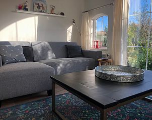 Comfortable sofa in Holiday Park de Bremakker, De Dennen Texel, with large windows and lots of natural light.