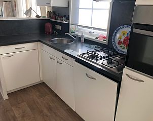 Modern kitchen in Holiday Park de Bremakker, De Dennen Texel, with white cabinets and gas stove.
