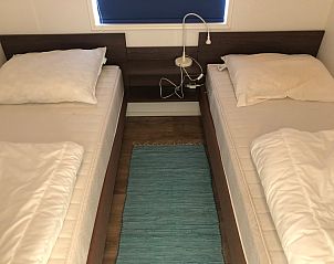 Bedroom with two single beds in Vakantiepark de Bremakker, De Dennen Texel, with wooden floor.