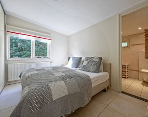 Schnes Schlafzimmer mit Doppelbett im Bungalowpark 't Hoogelandt, Texel, neben einem eigenen Badezimmer.