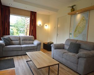 Spacious living room with a view of nature in Holiday home De Nagtegaal 19, De Dennen, Texel.