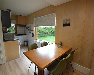 Dining area with garden view in Holiday Home De Nagtegaal 19, De Dennen, Texel, ideal for family dinners.