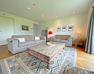 Ruime woonkamer van Appartement Bos en Duin 40, Texel, met rustieke houten tafel en sfeervolle verlichting.