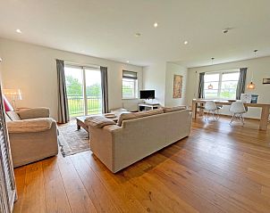 Open woonruimte van Appartement Bos en Duin 40 in De Dennen, Texel, met eetgedeelte en uitzicht op de groene omgeving.