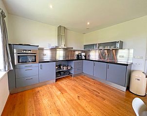 Moderne keuken van Appartement Bos en Duin 40, Texel, met roestvrijstalen apparatuur en veel werkruimte.