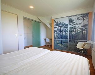 Stijlvolle slaapkamer in Appartement Bos en Duin 40, De Dennen, Texel, met tweepersoonsbed en bosdecoratie.