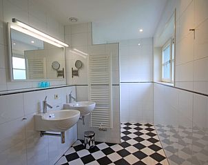 Moderne badkamer in Appartement Bos en Duin 40, De Dennen, Texel, met dubbele wastafel en ruime douche.