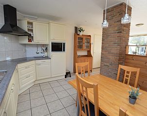 Modern kitchen with dining table in Holiday home de Parel 222, De Dennen, Texel.