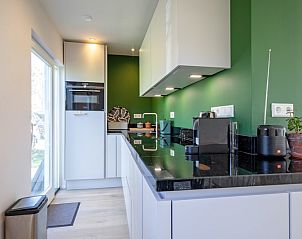 Modern kitchen in Bungalowpark Uterste Coogh - Bungalow 128 - Gerrit, De Dennen, Texel, with sleek finish.