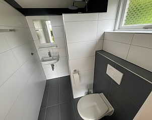 Modern bathroom in vacation home Wollewei, De Dennen, Texel, with toilet and sink.