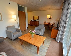 Interieur van vakantiehuis Narcis, De Dennen, Texel met comfortabele zithoek en eetgedeelte.