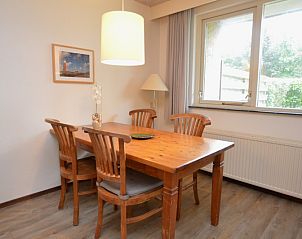 Eethoek in vakantiehuis Narcis, De Dennen, Texel met houten tafel en stoelen.