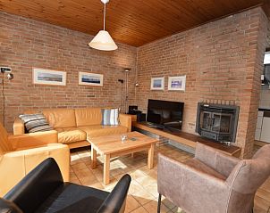 Vacation home de Parel 204 in De Dennen, Texel offers a cozy living room with a fireplace.