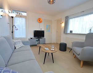 Moderne Sitzecke im Bungalow Uterste Coogh 104, De Dennen, Texel, mit Fernseher und dekorativen Elementen.