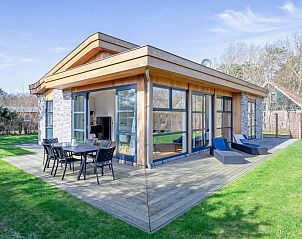 Vacation home De Vlinder in Bungalowpark 't Hoogelandt on Texel offers a spacious veranda with seating in the nature of De Dennen.