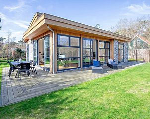 Vacation home De Vlinder in Bungalowpark 't Hoogelandt on Texel offers a spacious terrace with seating in the natural surroundings of De Dennen.
