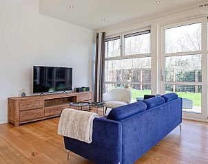 Stylish living room of Holiday Home De Vlinder in Bungalowpark 't Hoogelandt, Texel, overlooking the green surroundings of De Dennen.