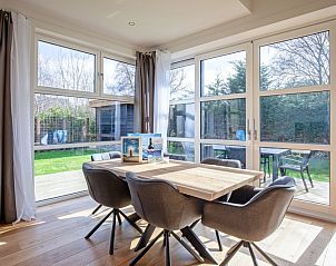 Dining area overlooking the garden in Holiday home De Vlinder, Bungalowpark 't Hoogelandt, De Dennen, Texel, for a relaxing stay.