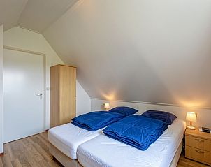 Schlafzimmer mit Doppelbett in 't Mienthuis - De Prins, Ferienhaus in De Dennen, Texel, mit Holzakzenten.