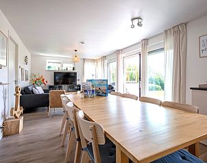 Lichte eetkamer in De Ankerplaats, vakantiehuis Texel, met grote ramen en tuindeur.