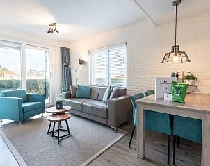 Cozy sitting area in Apartment Bos en Duin 12, Texel, with comfortable sofa and garden view.