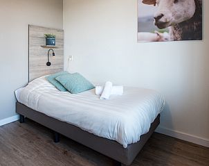 Cozy single room in Apartment Bos en Duin 12, Texel, with soft pillows and decorative accents.