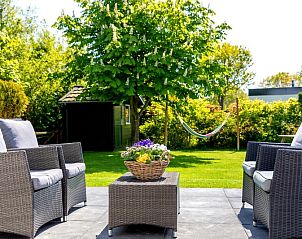Der Bungalowpark De Parel - WELMOED auf Texel verfgt ber eine einladende Sitzecke im Garten, umgeben von Grnflchen.