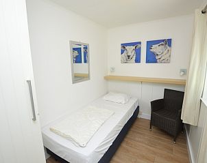 Schlafzimmer mit Kunstdekoration im Ferienhaus de Parel 282, De Dennen, Texel fr eine entspannte Atmosphre.