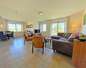 Gezellige zithoek in Appartement Bos en Duin 43, De Dennen, Texel met uitzicht op de groene omgeving.