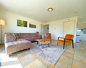 Stijlvolle woonkamer van Appartement Bos en Duin 43, Texel met moderne inrichting en toegang tot buitenruimte.