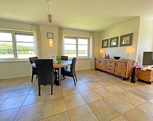 Eethoek met grote ramen in Appartement Bos en Duin 43, Texel, biedt uitzicht op de natuurlijke omgeving.