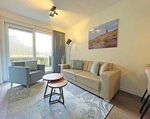 Lichte en ruime woonkamer van Appartement Bos en Duin 14, De Dennen, Texel met uitzicht op de natuur.