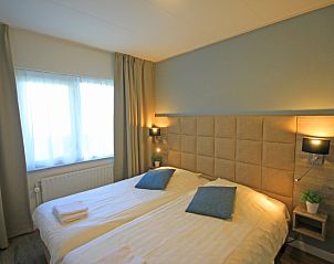 Sfeervolle slaapkamer met tweepersoonsbed in Appartement Bos en Duin 14, De Dennen, Texel voor een goede nachtrust.