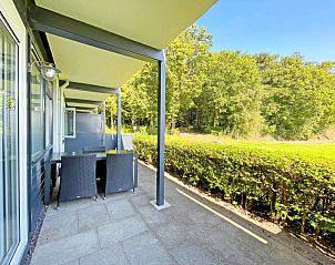 Ruim terras van Appartement Bos en Duin 14, De Dennen, Texel met uitzicht op het groene landschap.