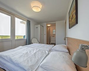 Schlafzimmer mit Doppelbett in Cottage 6, De Dennen, Texel, mit Blick auf die Natur.