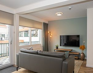 Spacious living room of Apartment Bos en Duin 28, Texel, with flat-screen TV and access to the balcony for fresh views.