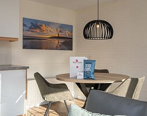 Cozy dining area in Apartment Bos en Duin 28, Texel, with atmospheric lighting and views of the Texel landscape.