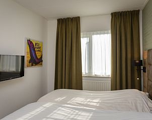Bedroom in Apartment Bos en Duin 28, Texel, with TV and cozy furnishings for a relaxing stay.