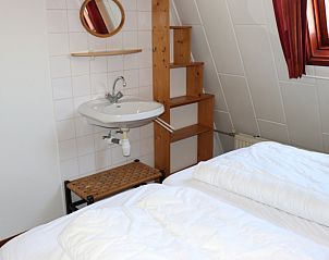 Schlafzimmer mit Waschbecken im Ferienhaus Gortersmient 246, De Dennen, Texel. Praktisch und komfortabel eingerichtet.