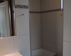 Stijlvolle badkamer in Vakantiehuis Gortersmient 216, De Dennen, Texel met bad en moderne tegels.