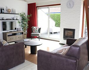 Lichte woonkamer in Vakantiehuis Gortersmient 216, De Dennen, Texel met schuifdeur naar terras.