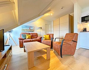 Dining area in Apartment Bos en Duin 34, De Dennen, Texel with wooden table and chairs.